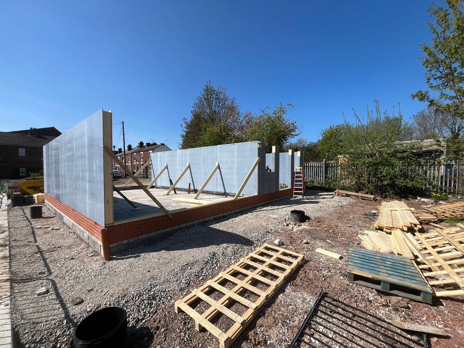 Wall panels erected and temporarily braced on a building platform